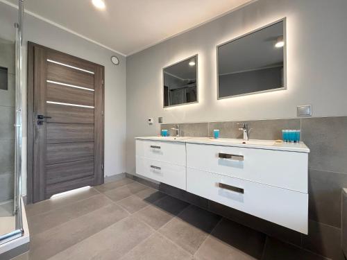a bathroom with a sink and a mirror at Park Leśnicki Homely Studios by BookingHost in Wrocław