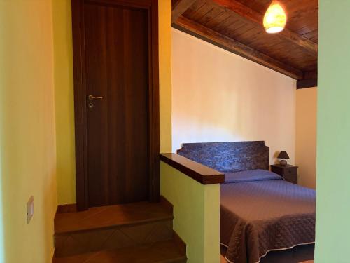 ein kleines Schlafzimmer mit einem Bett und einer Tür in der Unterkunft Il Muraglio in Belmonte Calabro