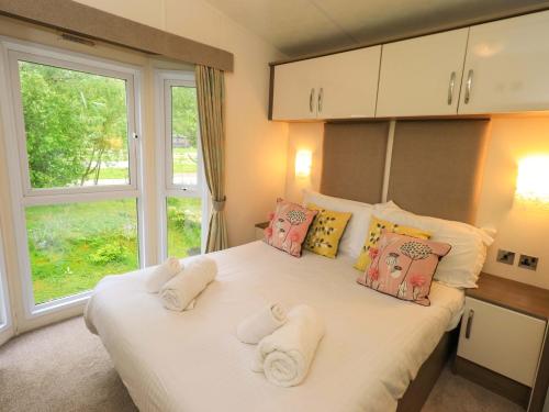 a bedroom with a large bed with towels on it at 41, Grandma's Cottage in Carnforth