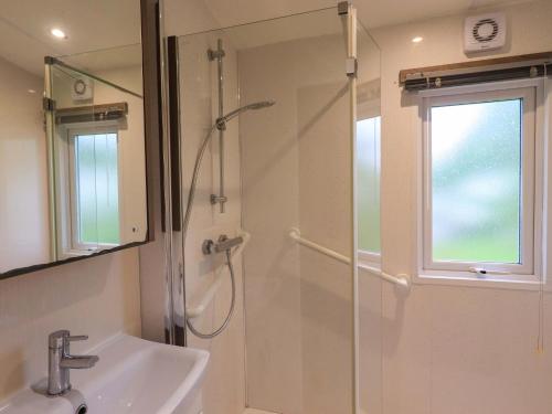 a bathroom with a shower and a sink and a mirror at 41, Grandma's Cottage in Carnforth