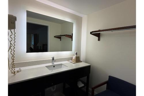 a bathroom with a sink and a large mirror at Travel Inn Buford near Mall of Georgia in Buford