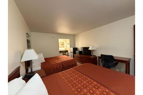 a hotel room with two beds and a desk at Travel Inn Buford near Mall of Georgia in Buford