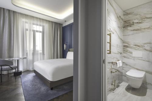 a hotel room with a bed and a toilet at InterContinental Rome Ambasciatori Palace by IHG in Rome