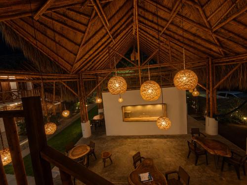 a room with tables and chairs and chandeliers at Boana hotel in Palomino