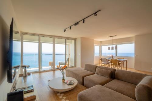 a living room with a couch and a table at Horizon living Madeira in Caniço