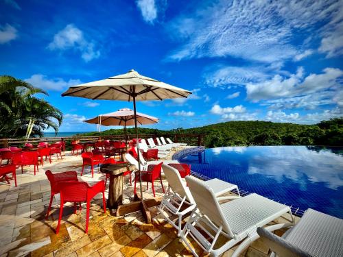 a group of chairs and umbrellas next to a pool at Villas do Pratagy VIP in Maceió
