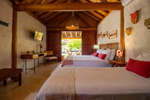 a bedroom with two beds in a room with a table at Casa Caroá - Chalé 1 in Japaratinga