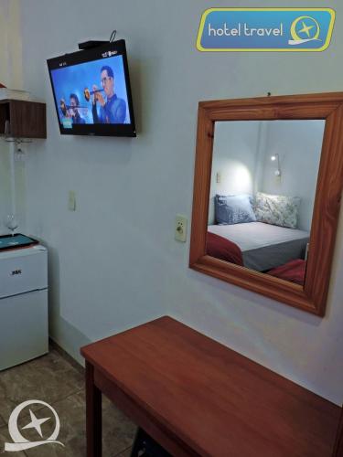 a room with a mirror and a tv on the wall at Hotel Travel Encarnación in Encarnación