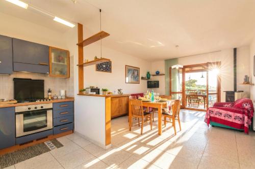 a kitchen and living room with a table and chairs at La Guzzetta Stintinese - Happy Rentals in Stintino