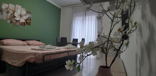 a bedroom with a bed and a vase with flowers at Casa Pirandello 3 min Metro in Sesto San Giovanni
