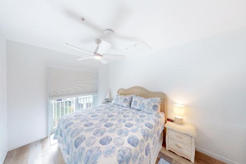 a bedroom with a bed and a ceiling fan at Snowbird-friendly condo in oceanfront complex with heated pool, BBQ, AC in Marathon