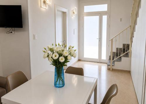 a vase of flowers on a table in a living room at Dimora Azzurra in Pachino