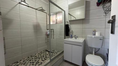a bathroom with a shower with a toilet and a sink at Polokwane Luxury Guest House in Polokwane