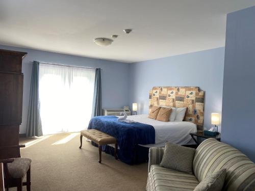 a blue bedroom with a bed and a couch at The Lakes at Ben Eoin Golf Club & Resort in Big Pond