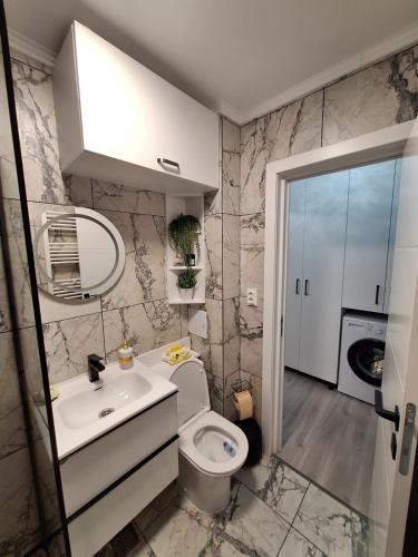 a bathroom with a toilet and a sink and a mirror at Nova Residence Craiova in Craiova