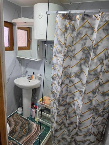 a shower curtain in a bathroom with a sink at Guest house Anka in Žabljak