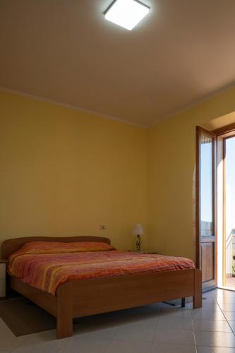a bedroom with a bed in a room with a window at Sonia House Discover Tuscany in Torniella