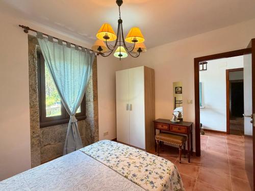 a bedroom with a bed and a desk and a window at Casa, al lado de las playas in Cee