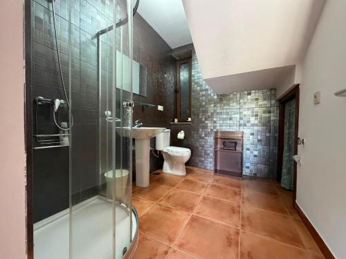 a bathroom with a shower and a toilet and a sink at Casa, al lado de las playas in Cee