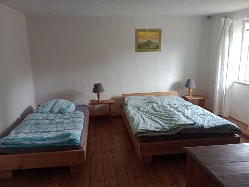 two beds in a room with two lamps on tables at Ferienhaus Lehmhaus in Häven