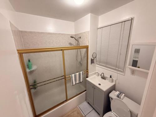 a bathroom with a shower and a toilet and a sink at Spacious 2BR Getaway Easy Access to NYC & Newark in Kearny