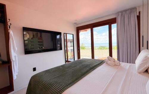 a bedroom with a large bed with a large window at Pousada Amazing Jeri in Jericoacoara