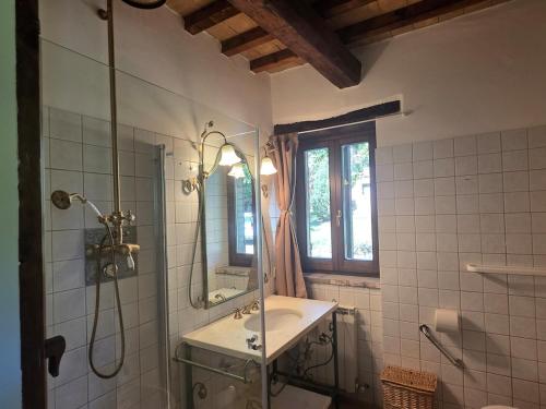 a bathroom with a sink and a shower and a mirror at Casale Montone , villa with private pool in Montone