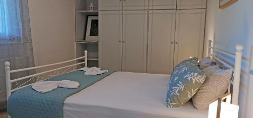 a bedroom with a bed with blue sheets and pillows at Lemon Tree Apartment with Garden in Chios