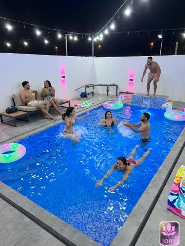 a group of people in a pool playing frisbee at شاليه غرام حتا - Hatta Romance Chalet in Būbādī