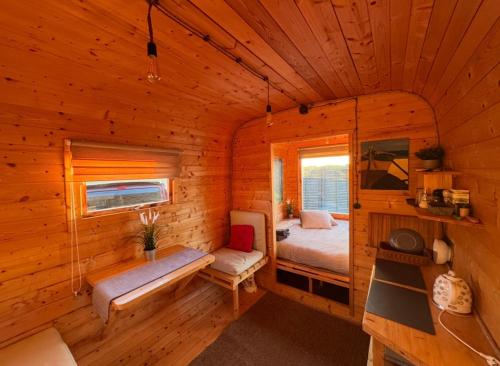 a bedroom in a log cabin with a bed and a bench at Doles skati, kubls - iekļauts cenā in Salaspils