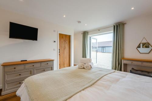 a bedroom with a large bed with a tv on the wall at 4 Bed in Otterden oc-d36009 in Otterden