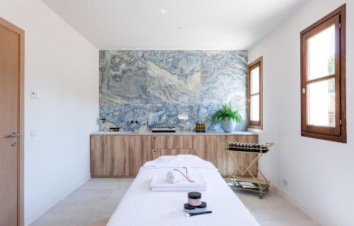 a bedroom with a bed and a wall with a mural at Kimpton Aysla Mallorca by IHG in Santa Ponsa