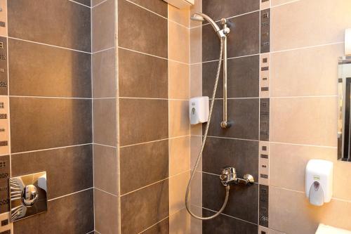 a bathroom with a shower with a tile wall at Khan Staria Dobrich Family Hotel in Dobrich