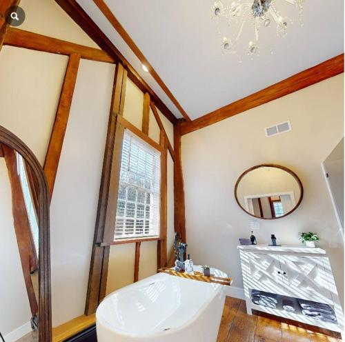 a bathroom with a white tub and a mirror at Riverbend Suite - Potter’s Mill in Bellevue