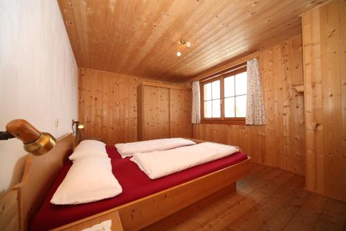 Un dormitorio con una cama en una habitación de madera. en Ferienhaus Hutegger, en Schladming