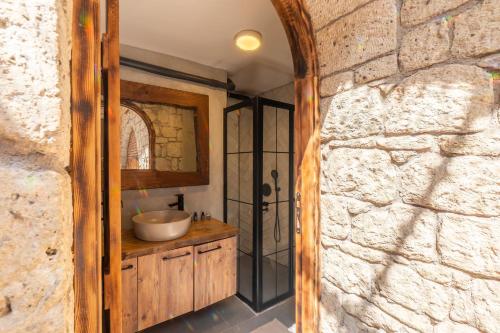 a bathroom with a sink and a stone wall at NURİYE ALACATI in Alaçatı