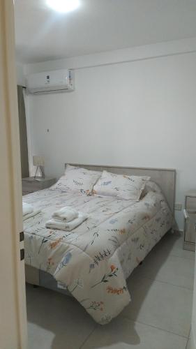 a bed in a white room with a bedspread on it at Dpto tte ibañez in Cipolletti