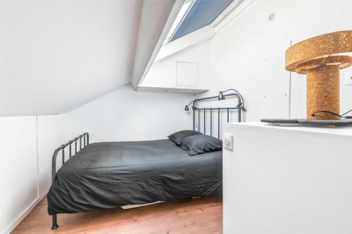 a bedroom with a bed in a room with a window at Rockefeller - Le petit Loft New-Yorkais 5 Min de la plage in Dunkerque