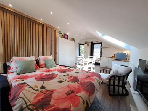 a bedroom with a bed with a red flower blanket at Studio 4 pers avec balcon et jardin in Sprimont
