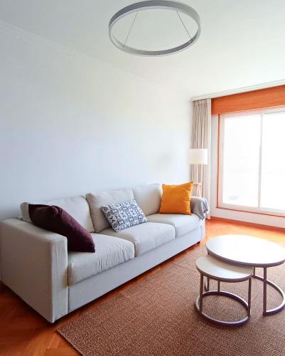 a white living room with a couch and a table at Viveiro Centro con Vistas in Viveiro