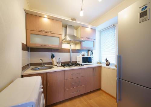 a small kitchen with a sink and a refrigerator at PaulMarie Apartments on Parijskoi Kommuny in Gomel