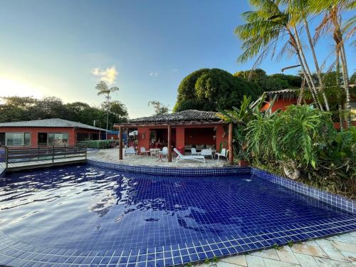 a swimming pool in front of a house at Villas do Pratagy VIP in Maceió