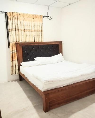 a bed sitting in a room with a window at Paragone Home Stay Modern 3BR Apartment Style Home AC 5 Min to Enderamulla Station 15 Minute Train Ride to Colombo in Wattala