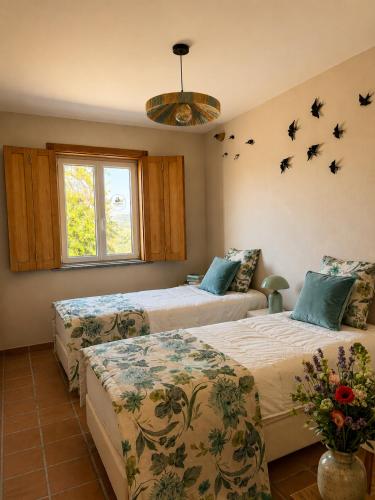 two beds in a room with birds on the wall at Iconic Vila d'Obidos in Óbidos