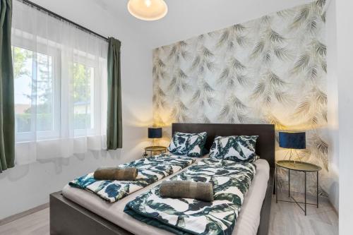 a bedroom with a bed with two pillows on it at Gery Apartman in Zamárdi