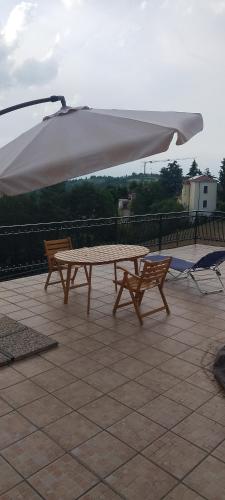 a picnic table and two chairs under an umbrella at B&B Cuccagna in Rocca deʼGiorgi