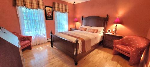 a bedroom with a large bed and a chair at Charlotte Garden Bed and Breakfast in Niagara-on-the-Lake