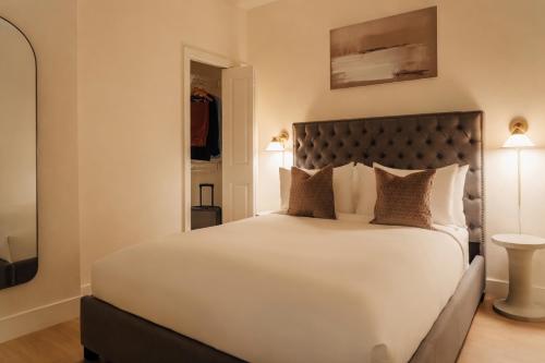 a bedroom with a large white bed with pillows at Ceros in Denver