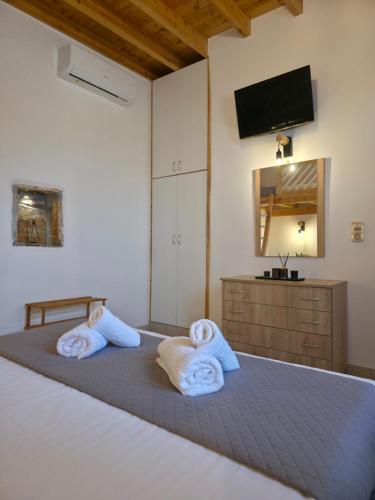 a bedroom with two towels on a bed with a television at Villa Natural View in Moutsoúna