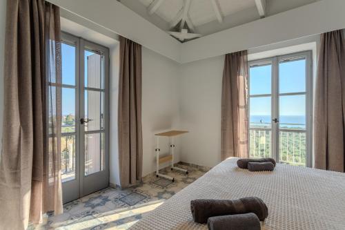 a bedroom with a large bed with large windows at Aether Blue Eco Villas in Agios Nikolaos
